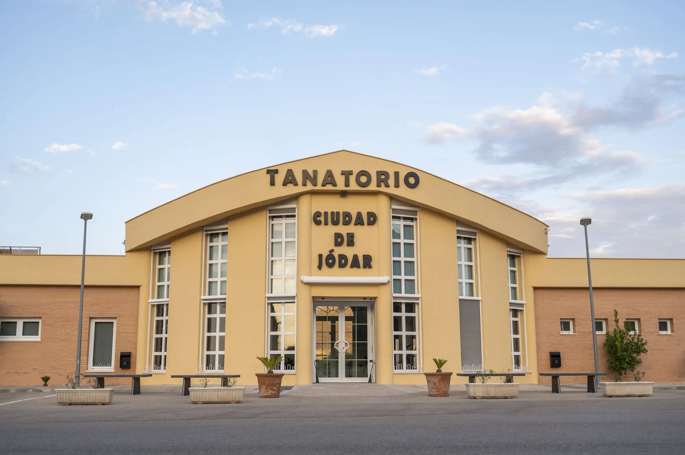 Entrada del complejo funerario de la carretera, con bancos y macetas
