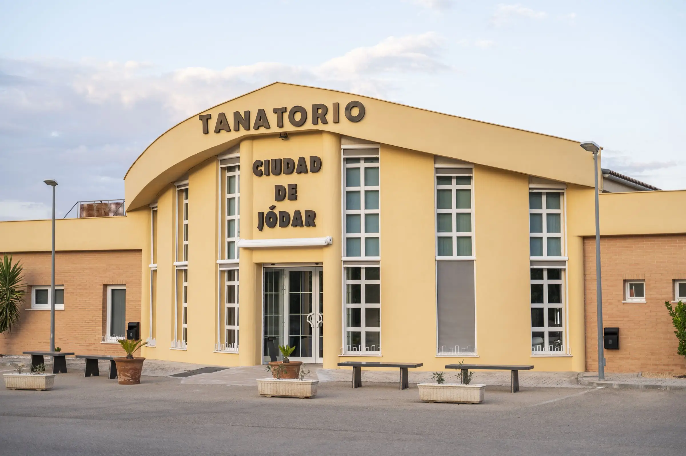 Fachada amarilla del complejo funerario con el rótulo «Tanatorio Ciudad de Jódar»