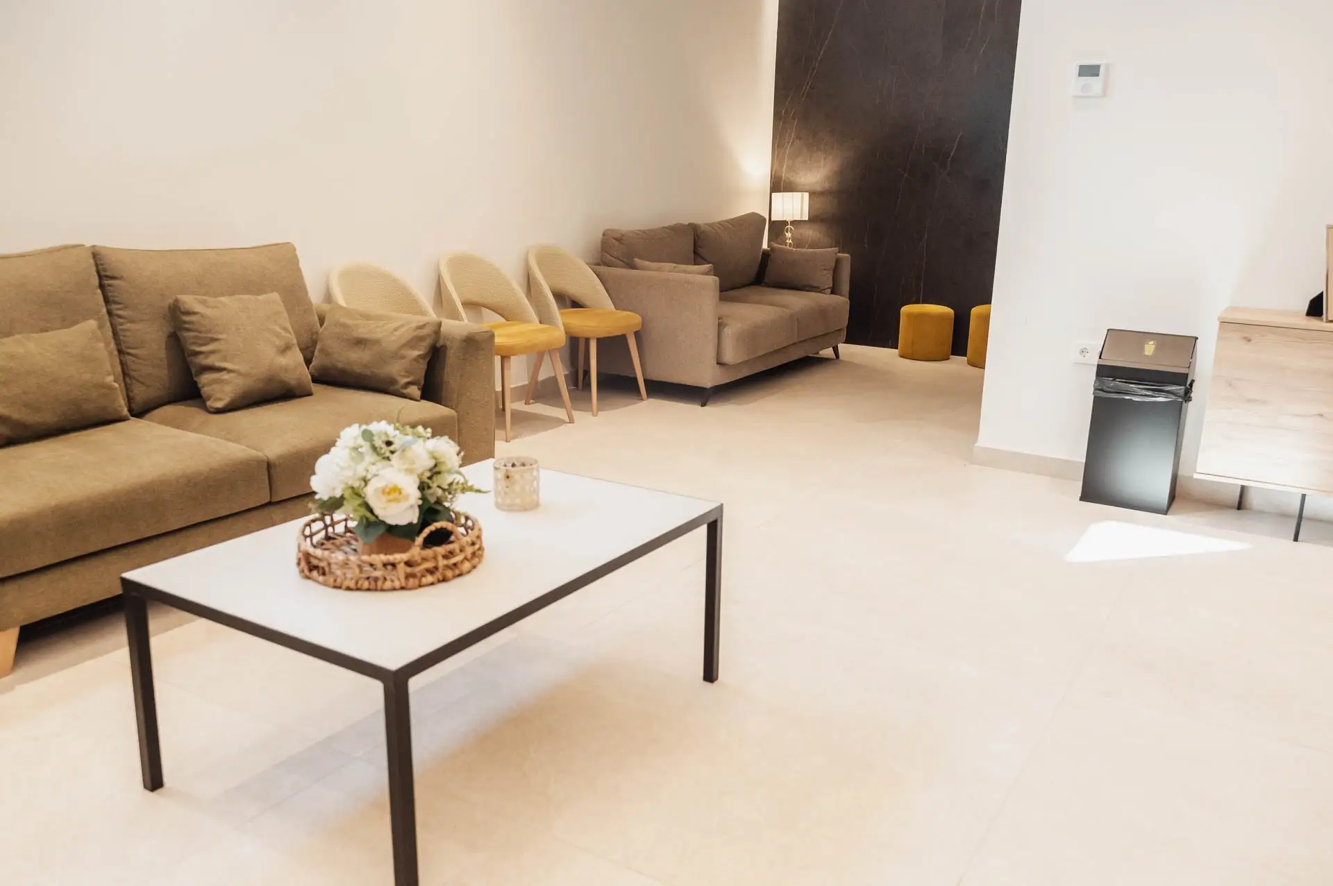 Sala con sofás verde oliva, butacas mostaza y flores
