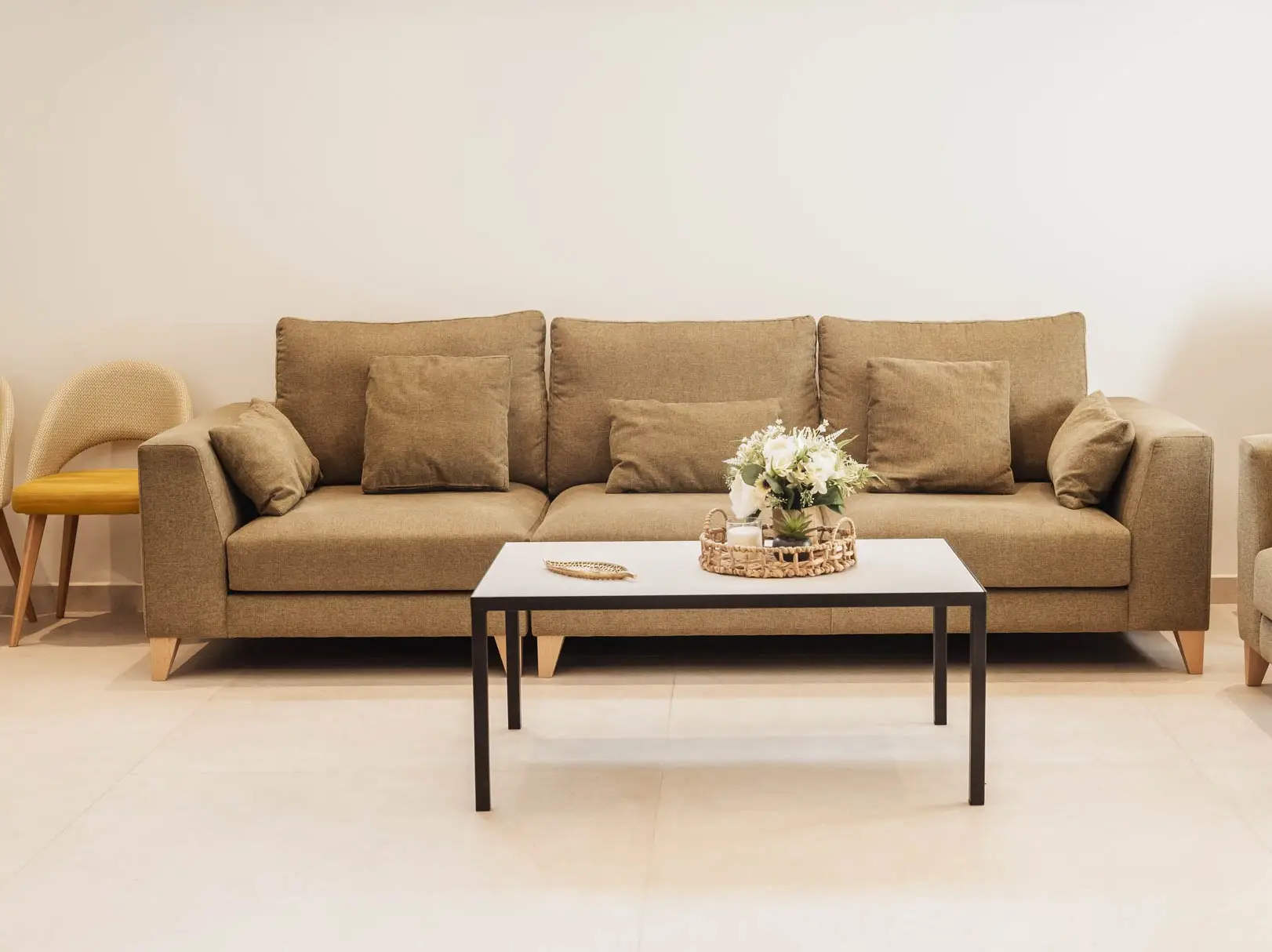 Sala de velatorio con sofá, butacas y un centro de flores blancas