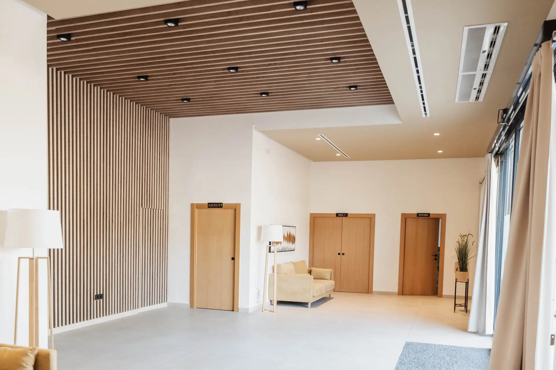 Recepción con techo de listones de madera y puertas de roble