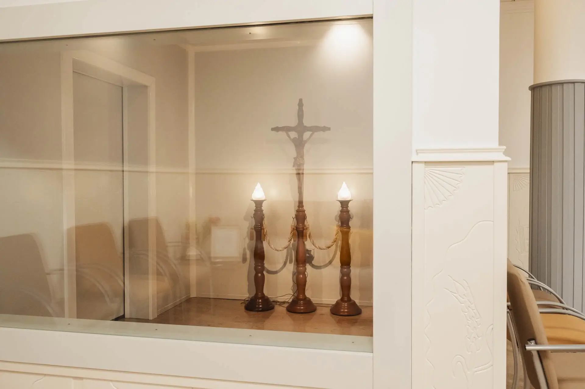 Sala de despedida tras un cristal, con candelabros
